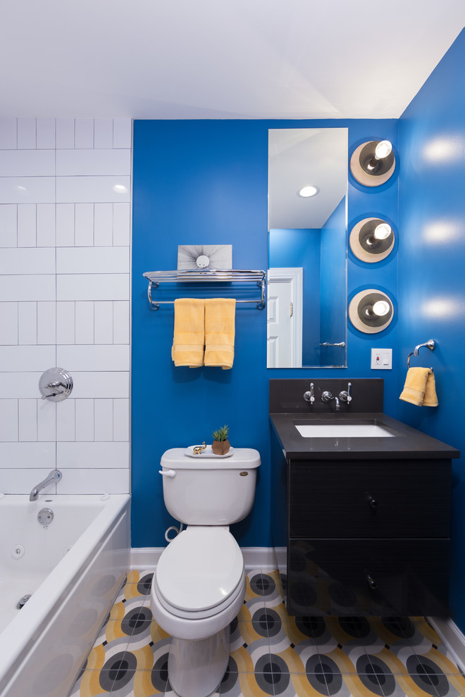 Idéer för mellanstora eklektiska en-suite badrum, med släta luckor, svarta skåp, ett platsbyggt badkar, en dusch/badkar-kombination, en toalettstol med hel cisternkåpa, vit kakel, keramikplattor, blå väggar, klinkergolv i keramik, ett undermonterad handfat och bänkskiva i kalksten