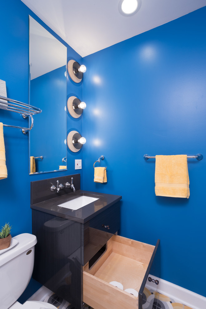 Inspiration pour une salle de bain principale bohème de taille moyenne avec un placard à porte plane, des portes de placard noires, une baignoire posée, un combiné douche/baignoire, WC à poser, un carrelage blanc, des carreaux de céramique, un mur bleu, un sol en carrelage de céramique, un lavabo encastré et un plan de toilette en calcaire.