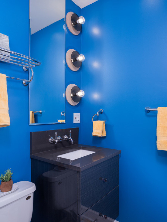 Idées déco pour une salle de bain principale éclectique en bois brun de taille moyenne avec un placard à porte plane, une baignoire posée, un combiné douche/baignoire, WC à poser, un carrelage blanc, des carreaux de céramique, un mur bleu, un sol en carrelage de céramique, un lavabo encastré et un plan de toilette en calcaire.