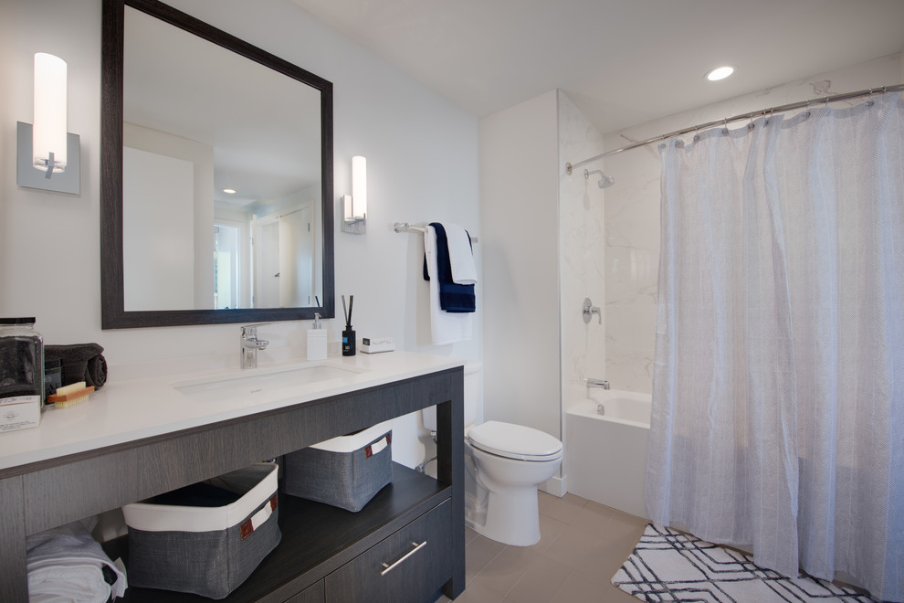 Exempel på ett litet klassiskt en-suite badrum, med släta luckor, skåp i slitet trä, ett platsbyggt badkar, en dusch/badkar-kombination, en toalettstol med separat cisternkåpa, beige kakel, cementkakel, vita väggar, ett undermonterad handfat och bänkskiva i kvarts