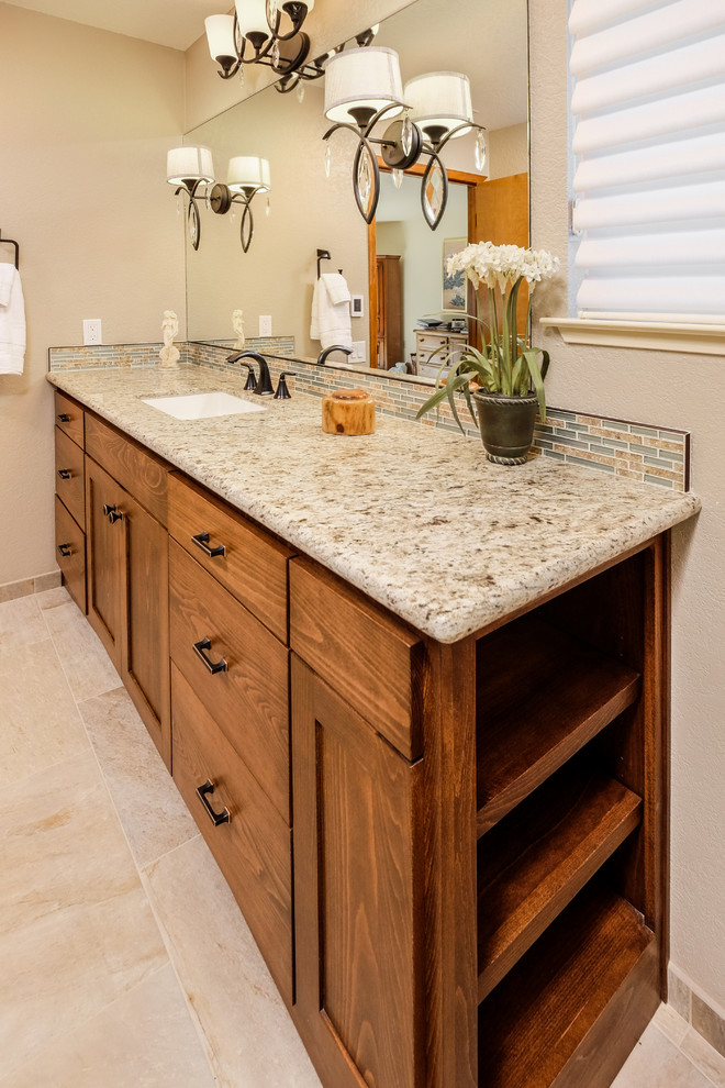 Example of a mid-sized mountain style master beige tile and porcelain tile beige floor, porcelain tile and single-sink alcove shower design in Sacramento with medium tone wood cabinets, beige walls, granite countertops, shaker cabinets, a one-piece toilet, an undermount sink, a hinged shower door, beige countertops and a built-in vanity