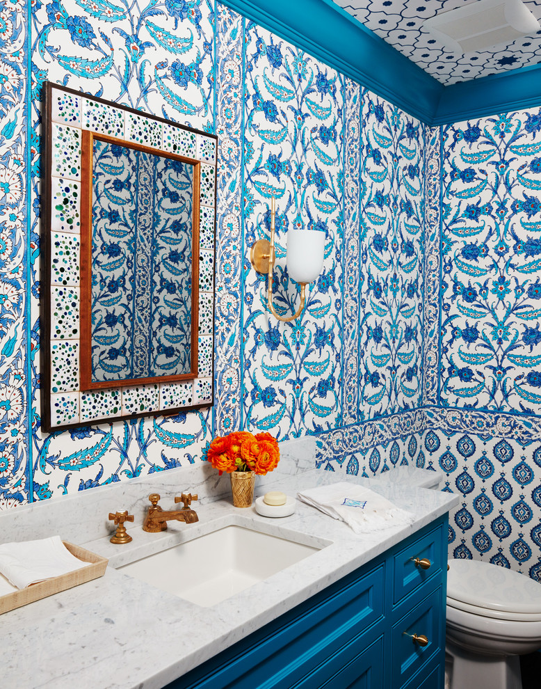 Ejemplo de cuarto de baño infantil costero de tamaño medio con armarios con paneles lisos, puertas de armario azules, paredes multicolor, lavabo bajoencimera y encimera de esteatita