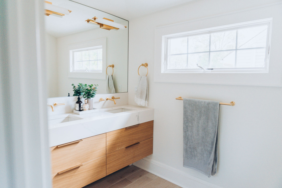 Inredning av ett modernt mellanstort vit vitt en-suite badrum, med släta luckor, skåp i ljust trä, en dusch i en alkov, vit kakel, klinkergolv i keramik, ett nedsänkt handfat, marmorbänkskiva, beiget golv och dusch med gångjärnsdörr