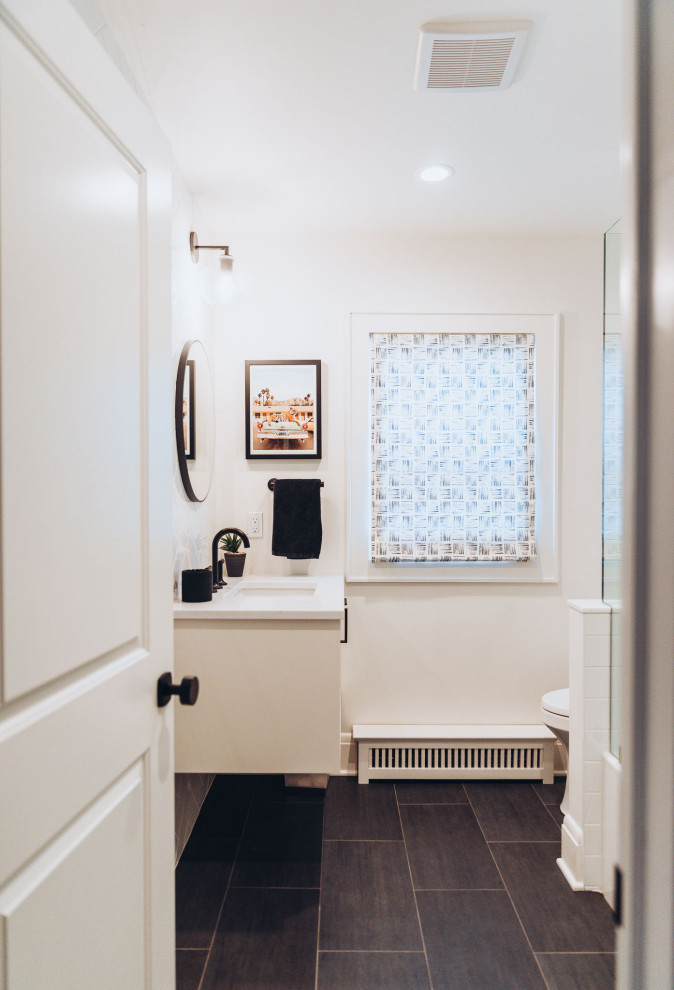 Aménagement d'une salle de bain moderne de taille moyenne pour enfant avec un placard à porte plane, des portes de placard blanches, une baignoire posée, un combiné douche/baignoire, WC à poser, un mur blanc, un sol en carrelage de céramique, un lavabo posé, un plan de toilette en marbre, un sol noir, une cabine de douche à porte battante, un plan de toilette blanc, meuble simple vasque, meuble-lavabo suspendu et un plafond à caissons.