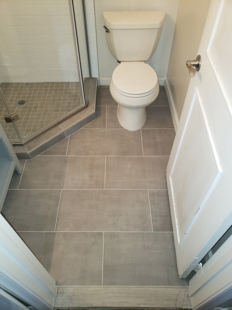 Small trendy 3/4 white tile and subway tile porcelain tile, gray floor and single-sink corner shower photo in DC Metro with recessed-panel cabinets, gray cabinets, a two-piece toilet, beige walls, an undermount sink, quartzite countertops, a hinged shower door and a built-in vanity