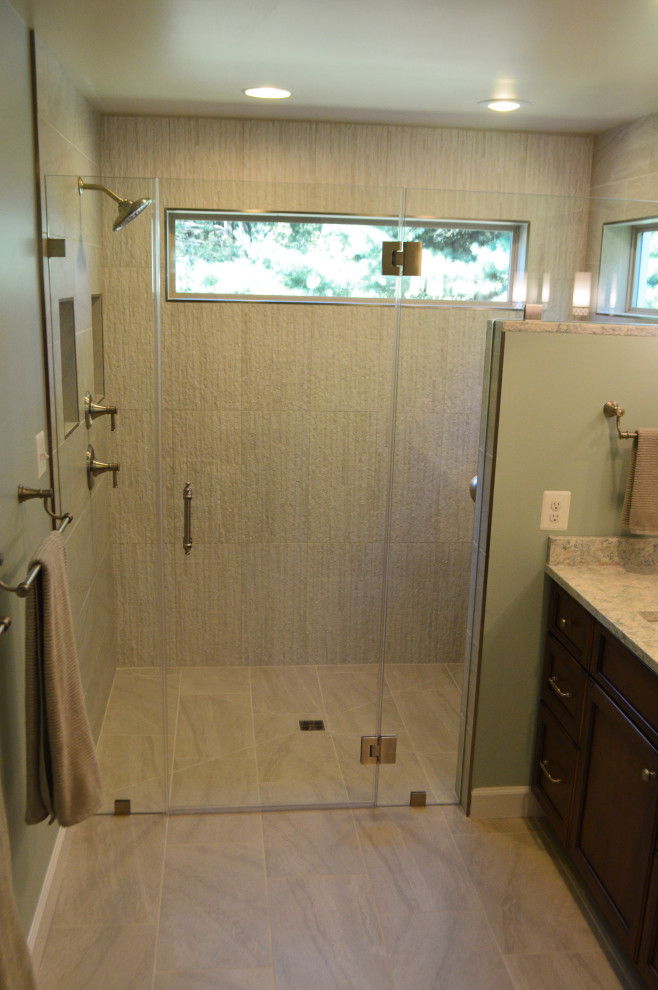 Photo of a large traditional ensuite bathroom in DC Metro with flat-panel cabinets, brown cabinets, a built-in shower, a one-piece toilet, blue walls, porcelain flooring, a submerged sink, engineered stone worktops, grey floors, a hinged door, blue worktops, a shower bench and a built in vanity unit.