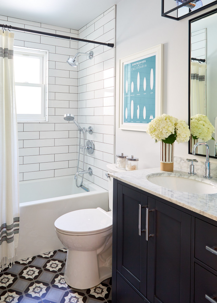 Photo of a medium sized coastal shower room bathroom in San Francisco with shaker cabinets, black cabinets, an alcove bath, a shower/bath combination, white tiles, white walls, a submerged sink, multi-coloured floors, a shower curtain, grey worktops, a one-piece toilet, metro tiles, mosaic tile flooring, marble worktops and a single sink.