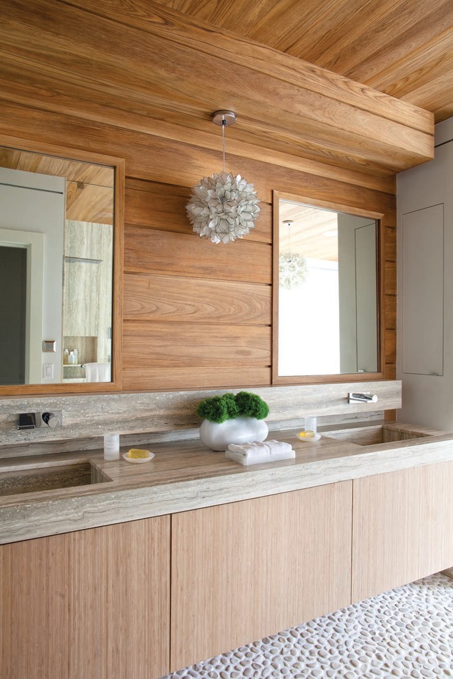 Diseño de cuarto de baño principal contemporáneo con lavabo integrado, armarios con paneles lisos, puertas de armario de madera clara, suelo de baldosas tipo guijarro, suelo gris y espejo con luz