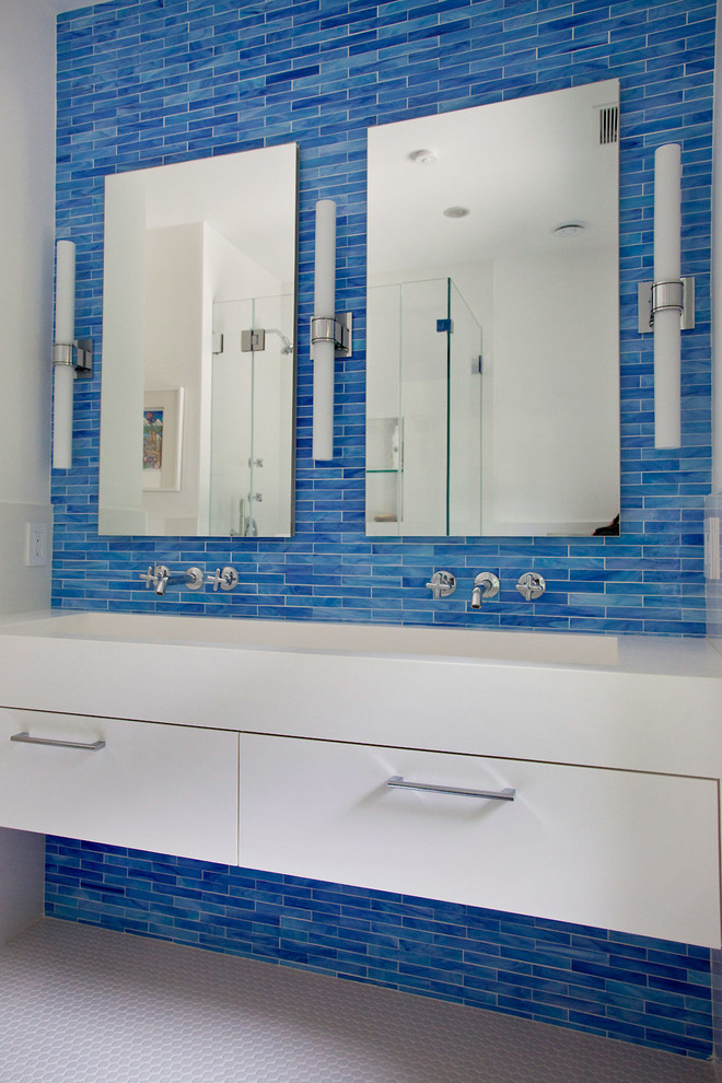 Modelo de cuarto de baño rectangular actual con lavabo de seno grande, armarios con paneles lisos, puertas de armario blancas, baldosas y/o azulejos azules, paredes azules y suelo con mosaicos de baldosas