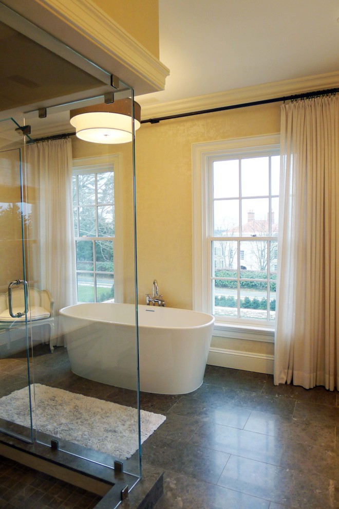 Foto på ett stort funkis brun en-suite badrum, med gula skåp, ett fristående badkar, en hörndusch, brunt golv, dusch med gångjärnsdörr, klinkergolv i porslin och gula väggar