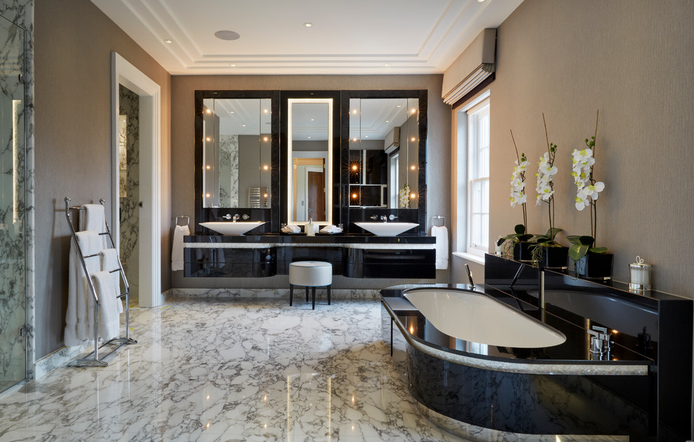 Imagen de cuarto de baño principal, contemporáneo, con lavabo sobreencimera, armarios con paneles lisos, puertas de armario negras, bañera encastrada sin remate y paredes beige