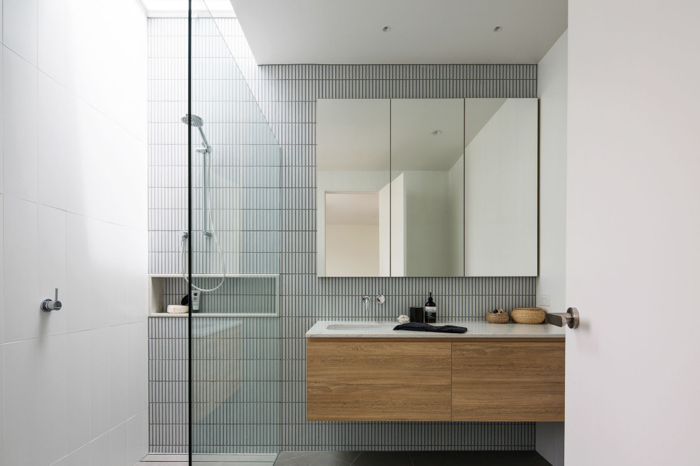 Ispirazione per una stanza da bagno padronale minimal di medie dimensioni con ante lisce, piastrelle bianche, piastrelle a mosaico, top in quarzo composito, un lavabo e mobile bagno sospeso