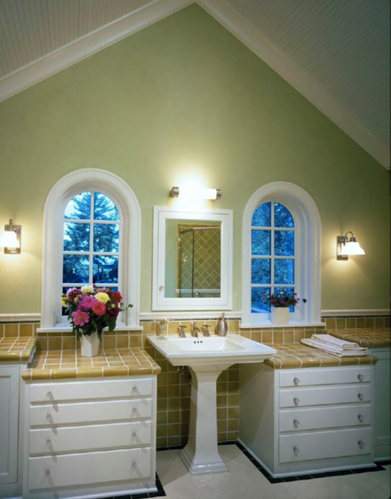 На фото: ванная комната в классическом стиле с раковиной с пьедесталом, столешницей из плитки, зелеными стенами и белыми фасадами