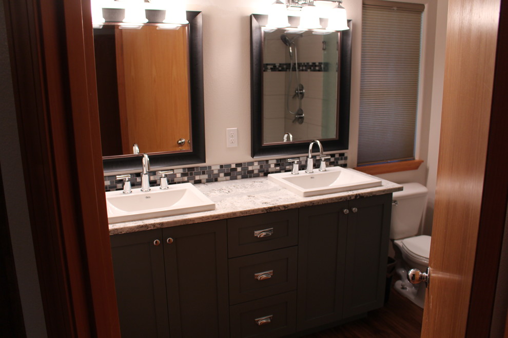 Mittelgroßes Modernes Badezimmer En Suite mit Einbauwaschbecken, Schrankfronten im Shaker-Stil, grauen Schränken, Granit-Waschbecken/Waschtisch, Wandtoilette mit Spülkasten, grauen Fliesen und braunem Holzboden in Portland