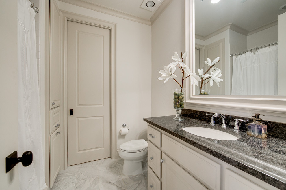 This is an example of a large traditional shower room bathroom in Dallas with raised-panel cabinets, white cabinets, an alcove shower, beige walls, marble flooring, a submerged sink, granite worktops, grey floors, a shower curtain and an alcove bath.