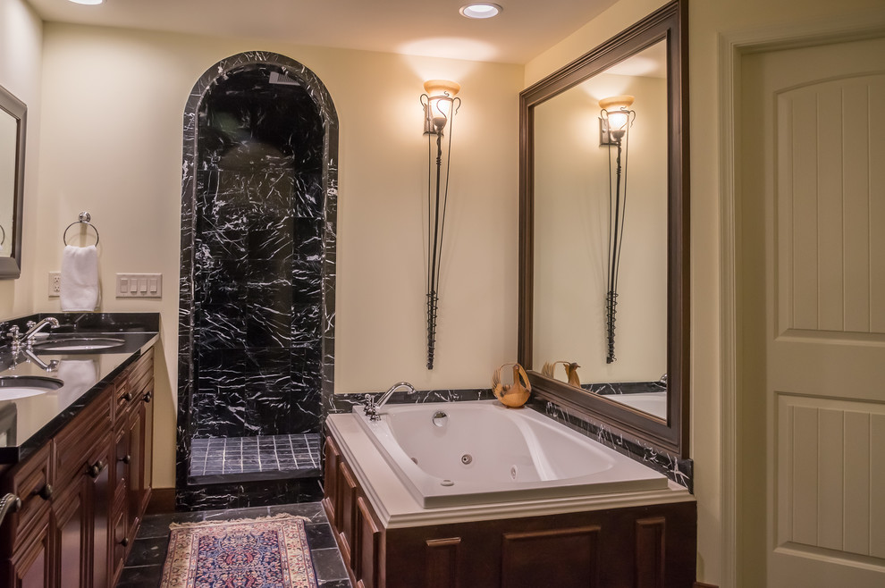 Medium sized traditional shower room bathroom in Other with dark wood cabinets, a built-in bath, an alcove shower, black and white tiles, stone tiles, beige walls, ceramic flooring, a submerged sink, granite worktops, black floors, an open shower and black worktops.