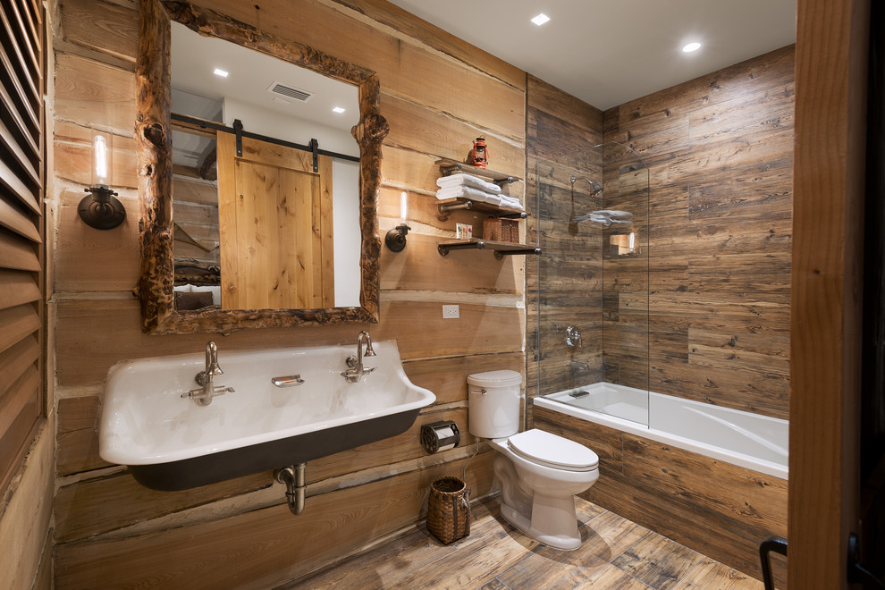 Exempel på ett rustikt badrum med dusch, med en dusch/badkar-kombination, en toalettstol med separat cisternkåpa, bruna väggar, ett avlångt handfat, brunt golv, med dusch som är öppen och ett badkar i en alkov
