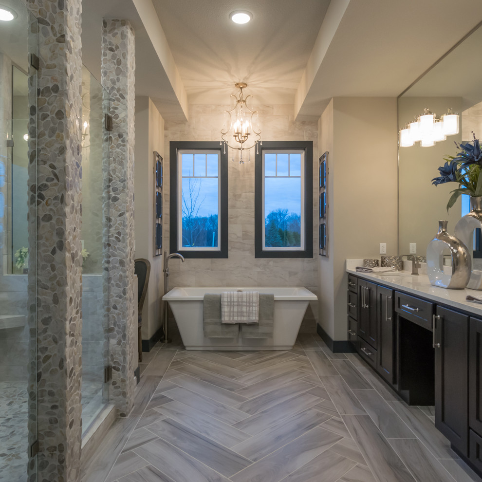 Bathroom - mid-sized transitional master brown tile and ceramic tile ceramic tile and gray floor bathroom idea in Other with recessed-panel cabinets, dark wood cabinets, a two-piece toilet, gray walls, an undermount sink and quartzite countertops
