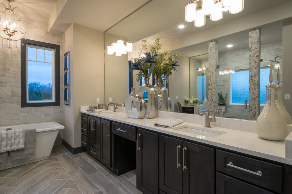 Inspiration for a mid-sized transitional master brown tile and ceramic tile ceramic tile and gray floor bathroom remodel in Other with recessed-panel cabinets, dark wood cabinets, a two-piece toilet, gray walls, an undermount sink and quartzite countertops