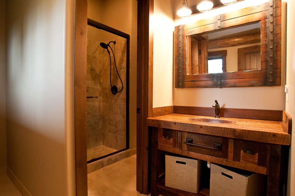 Foto på ett mellanstort rustikt brun badrum med dusch, med skåp i mörkt trä, en dusch i en alkov, brun kakel, porslinskakel, beige väggar, ett nedsänkt handfat, träbänkskiva och dusch med skjutdörr