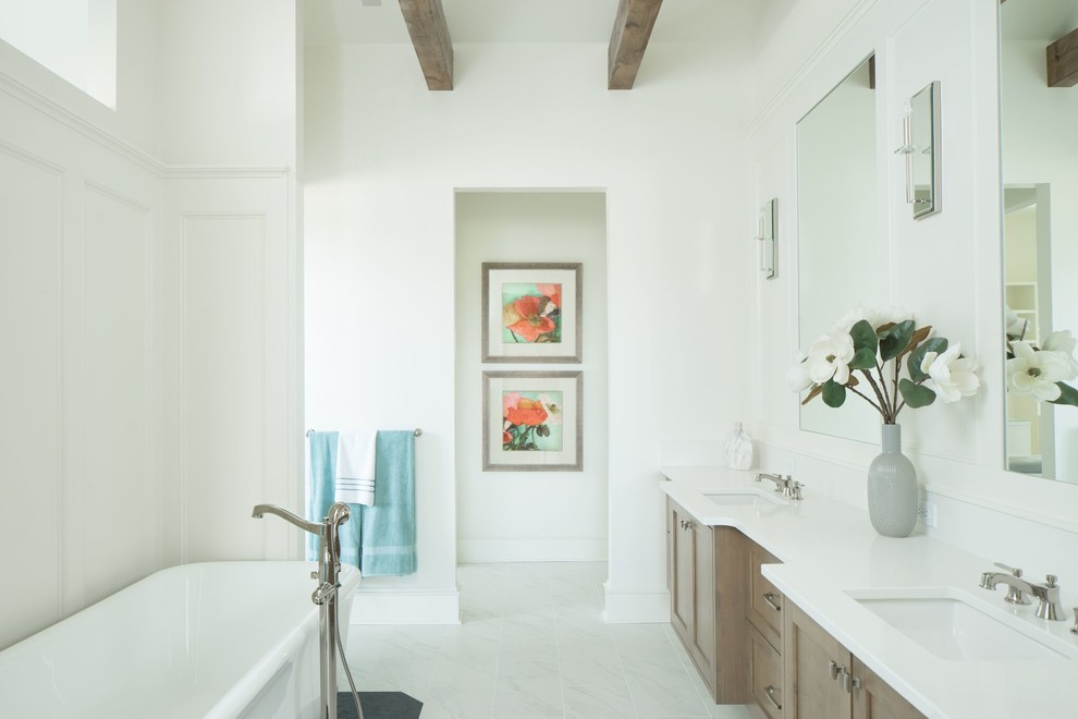 Стильный дизайн: главная ванная комната в стиле неоклассика (современная классика) с фасадами с утопленной филенкой, светлыми деревянными фасадами, отдельно стоящей ванной, белыми стенами, врезной раковиной, белым полом и белой столешницей - последний тренд