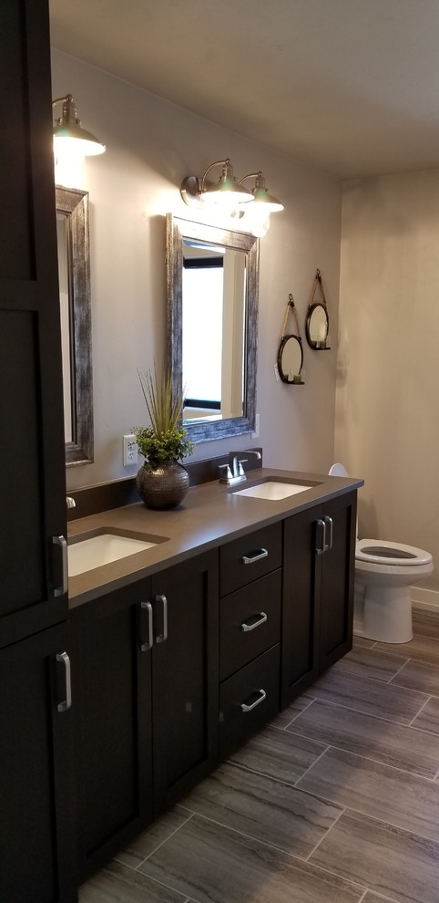 Foto de cuarto de baño infantil tradicional renovado de tamaño medio con sanitario de una pieza, paredes grises, encimera de granito y suelo marrón