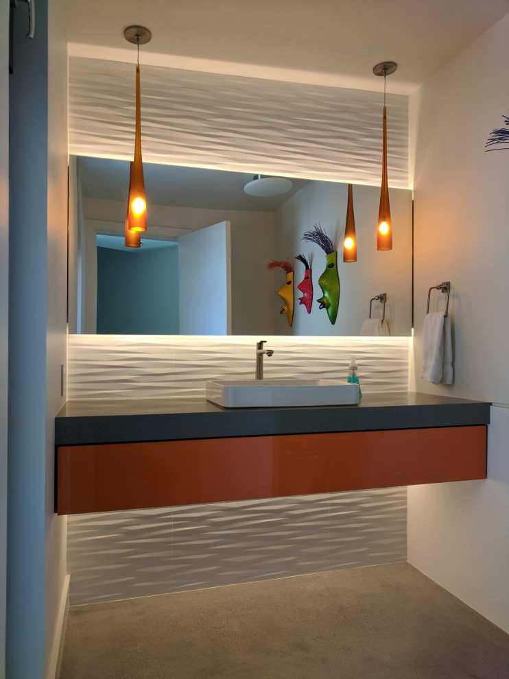 Diseño de cuarto de baño contemporáneo con armarios con paneles lisos, puertas de armario naranjas, baldosas y/o azulejos blancos, paredes blancas, suelo de cemento, lavabo sobreencimera, suelo gris y encimeras grises