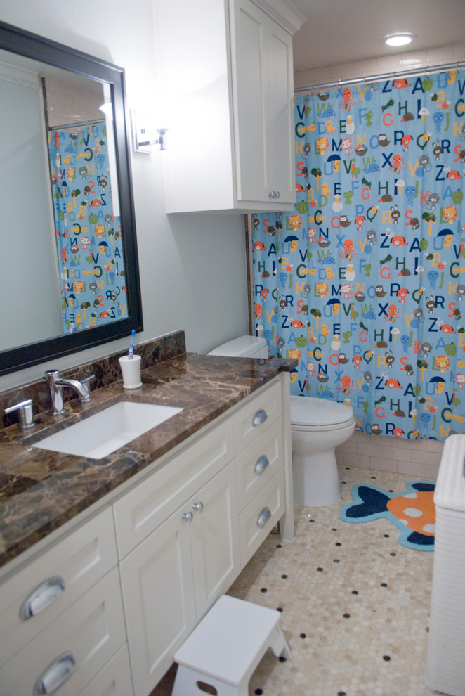 На фото: детская ванная комната в стиле кантри с фасадами в стиле шейкер, бежевыми фасадами, полновстраиваемой ванной, душем над ванной, раздельным унитазом, бежевой плиткой, керамической плиткой, синими стенами, полом из керамической плитки, врезной раковиной и мраморной столешницей с