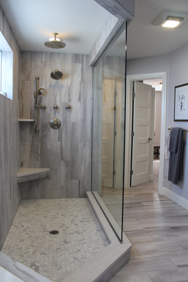 Réalisation d'une salle de bain principale minimaliste en bois foncé de taille moyenne avec un placard avec porte à panneau surélevé, une baignoire d'angle, une douche d'angle, un carrelage gris, des carreaux de porcelaine, un mur gris, un sol en carrelage de porcelaine et un plan de toilette en quartz modifié.