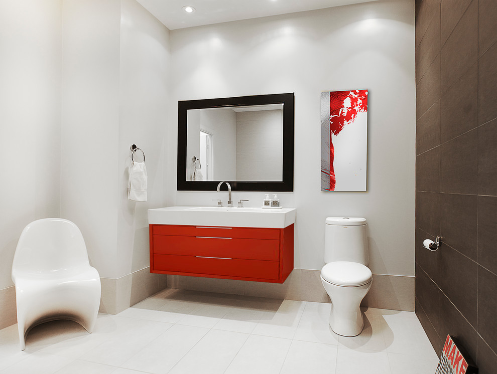 Immagine di una stanza da bagno minimal con lavabo integrato, ante lisce, ante rosse, WC monopezzo e pareti bianche