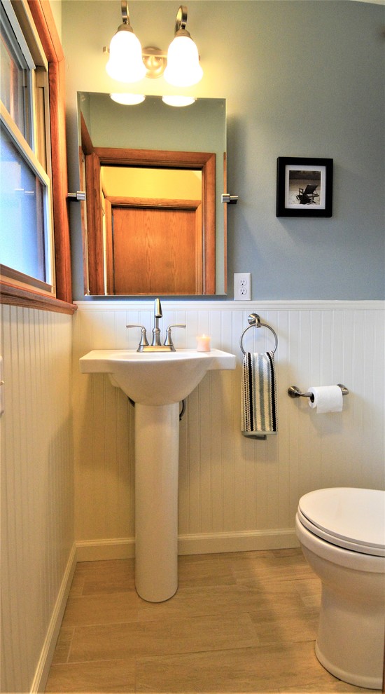 Foto på ett litet vintage badrum med dusch, med en toalettstol med separat cisternkåpa, grå väggar, ljust trägolv, ett piedestal handfat, bänkskiva i akrylsten, beiget golv, luckor med upphöjd panel och skåp i mörkt trä