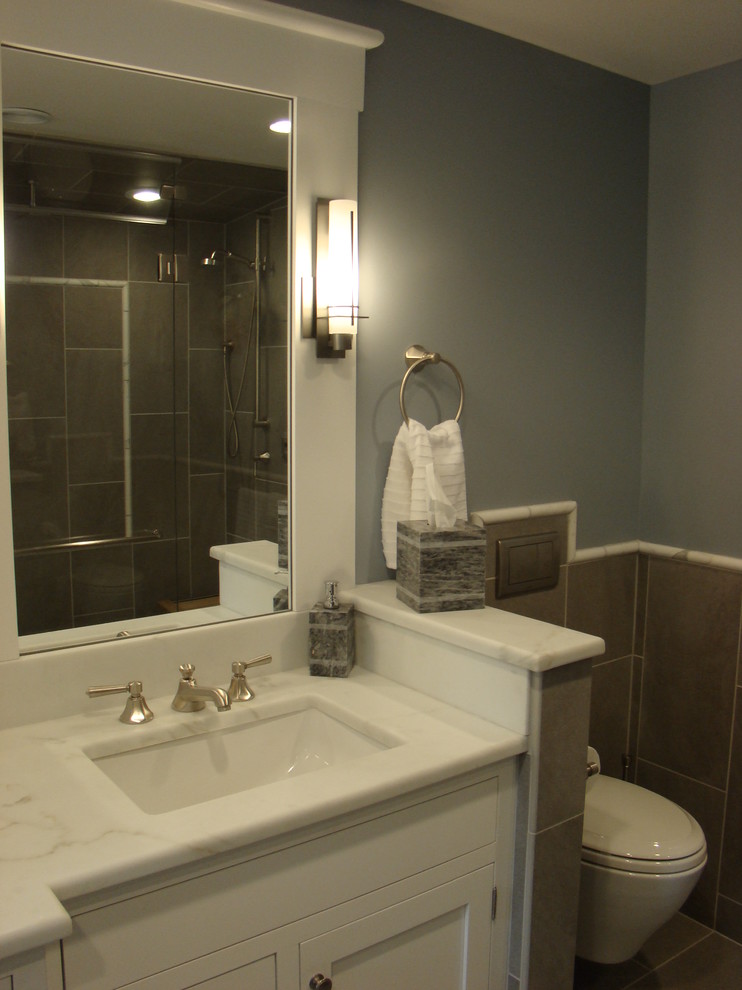 Walk-in shower - mid-sized traditional master gray tile and porcelain tile porcelain tile walk-in shower idea in Portland Maine with an undermount sink, beaded inset cabinets, white cabinets, marble countertops, a wall-mount toilet and blue walls