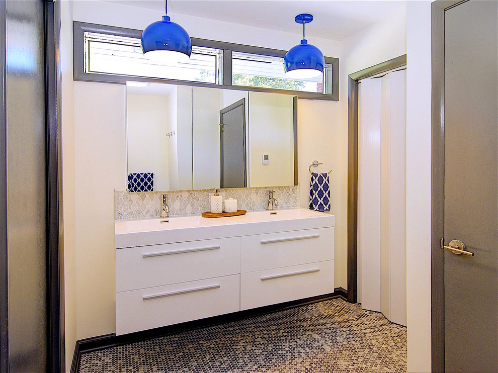 Medium sized retro family bathroom in Newark with flat-panel cabinets, white cabinets, an alcove bath, a shower/bath combination, a two-piece toilet, ceramic tiles, white walls, ceramic flooring, an integrated sink and glass worktops.