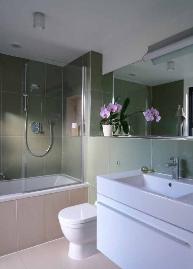 Exempel på ett mellanstort modernt badrum, med ett väggmonterat handfat, släta luckor, vita skåp, ett platsbyggt badkar, en dusch/badkar-kombination, en toalettstol med hel cisternkåpa, grön kakel, keramikplattor och klinkergolv i keramik