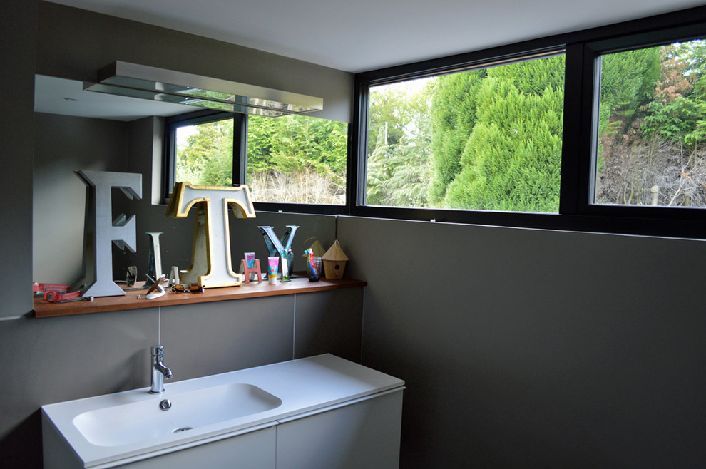 This is an example of a small contemporary bathroom in Surrey with a wall-mounted sink, flat-panel cabinets, white cabinets, a walk-in shower, ceramic tiles, ceramic flooring, grey tiles and grey walls.