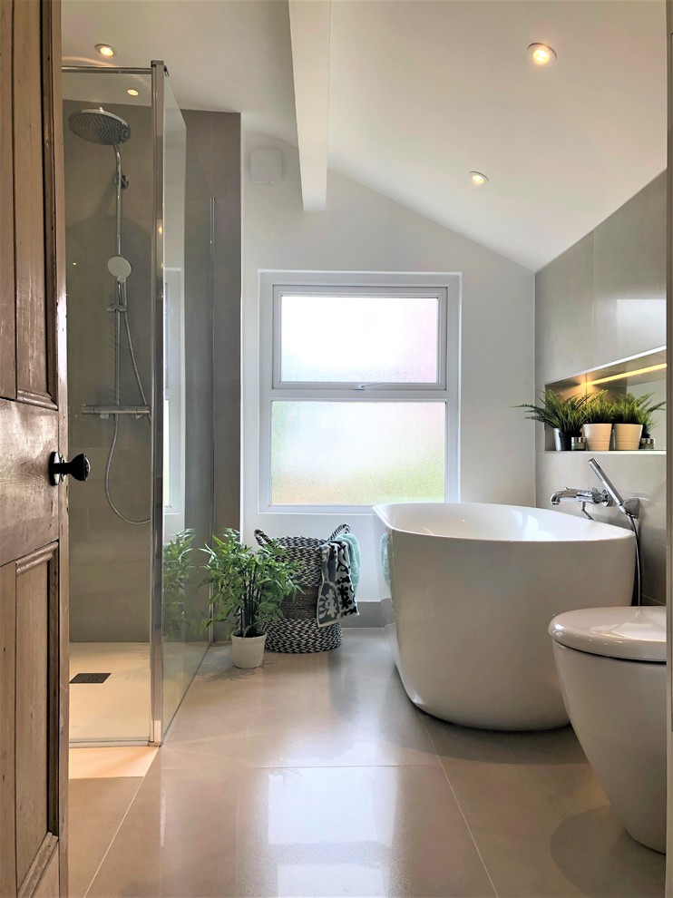 Exempel på ett mellanstort modernt badrum för barn, med ett fristående badkar, en öppen dusch, grå kakel, porslinskakel, grå väggar, klinkergolv i porslin, ett fristående handfat, grått golv och med dusch som är öppen