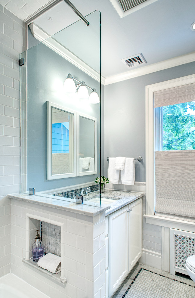 Источник вдохновения для домашнего уюта: маленькая главная ванная комната в стиле неоклассика (современная классика) с плоскими фасадами, белыми фасадами, ванной в нише, раздельным унитазом, белой плиткой, керамической плиткой, синими стенами, полом из мозаичной плитки, врезной раковиной, мраморной столешницей и душем над ванной для на участке и в саду