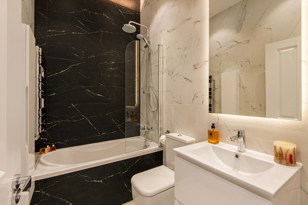 Inspiration for a medium sized contemporary family bathroom in London with white cabinets, a hot tub, a one-piece toilet, black and white tiles, porcelain tiles and porcelain flooring.