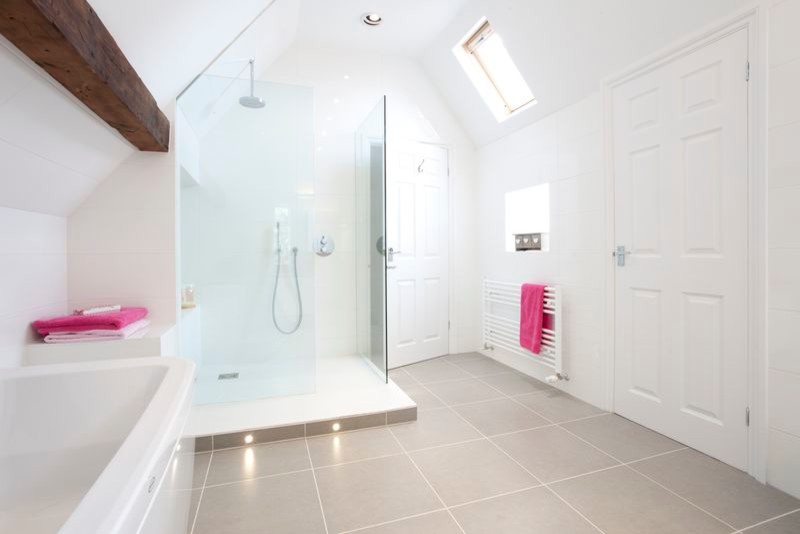 Photo of a large contemporary family bathroom in Oxfordshire with a vessel sink, flat-panel cabinets, white cabinets, wooden worktops, a one-piece toilet, grey tiles, porcelain tiles, white walls and porcelain flooring.