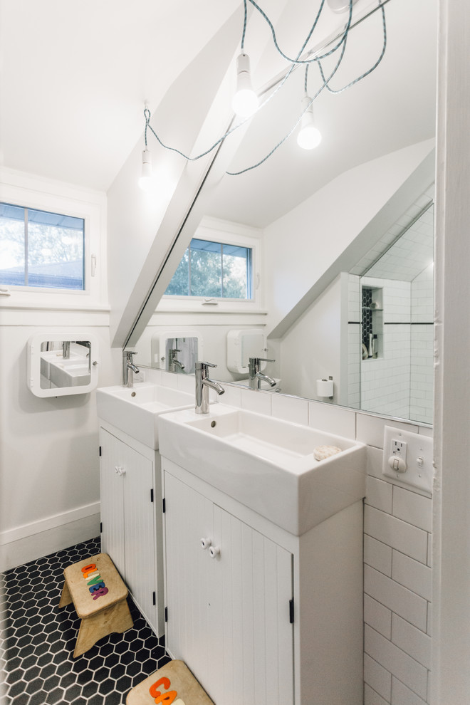 Foto på ett litet funkis badrum för barn, med möbel-liknande, vita skåp, en dusch i en alkov, en toalettstol med separat cisternkåpa, svart och vit kakel, porslinskakel, grå väggar, klinkergolv i porslin och ett väggmonterat handfat