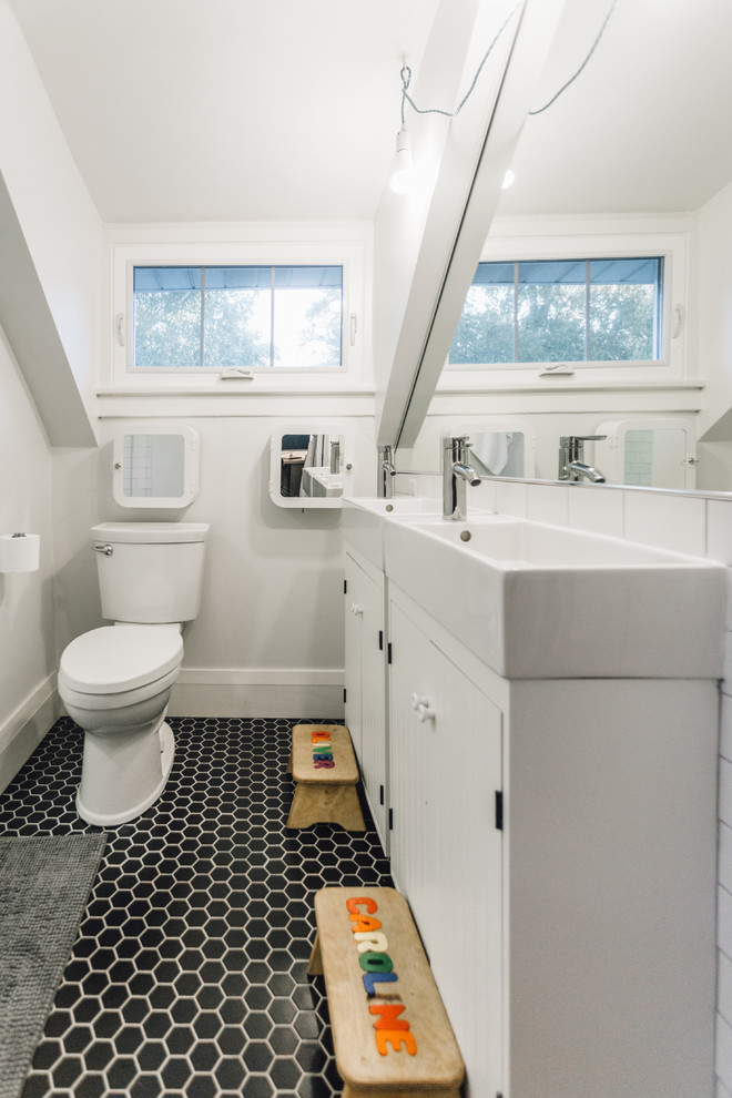 Small contemporary family bathroom in Minneapolis with freestanding cabinets, white cabinets, an alcove shower, a two-piece toilet, black and white tiles, porcelain tiles, grey walls, porcelain flooring and a wall-mounted sink.