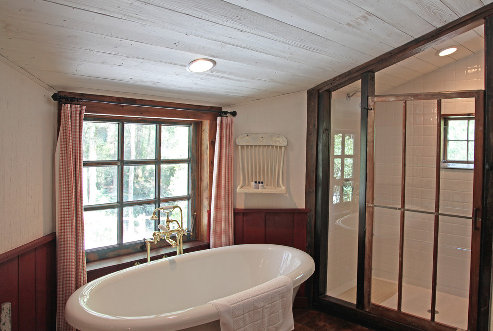 Imagen de cuarto de baño principal rural de tamaño medio con bañera con patas, ducha abierta, paredes blancas y suelo de madera oscura