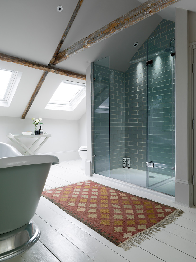 Landhaus Badezimmer mit freistehender Badewanne, Duschnische, Metrofliesen, weißer Wandfarbe, gebeiztem Holzboden, blauen Fliesen und Falttür-Duschabtrennung in Sonstige