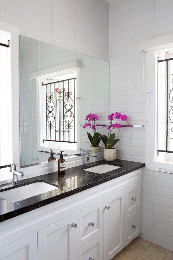 Traditional bathroom in Brisbane with beaded cabinets, white cabinets, porcelain tiles, white walls, limestone flooring, a submerged sink and granite worktops.