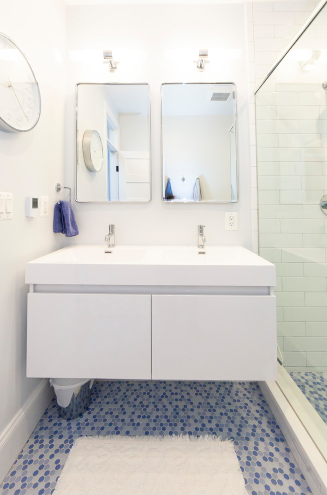 Idéer för funkis vitt badrum med dusch, med släta luckor, vita skåp, vit kakel, tunnelbanekakel, mosaikgolv, ett integrerad handfat, blått golv och dusch med gångjärnsdörr