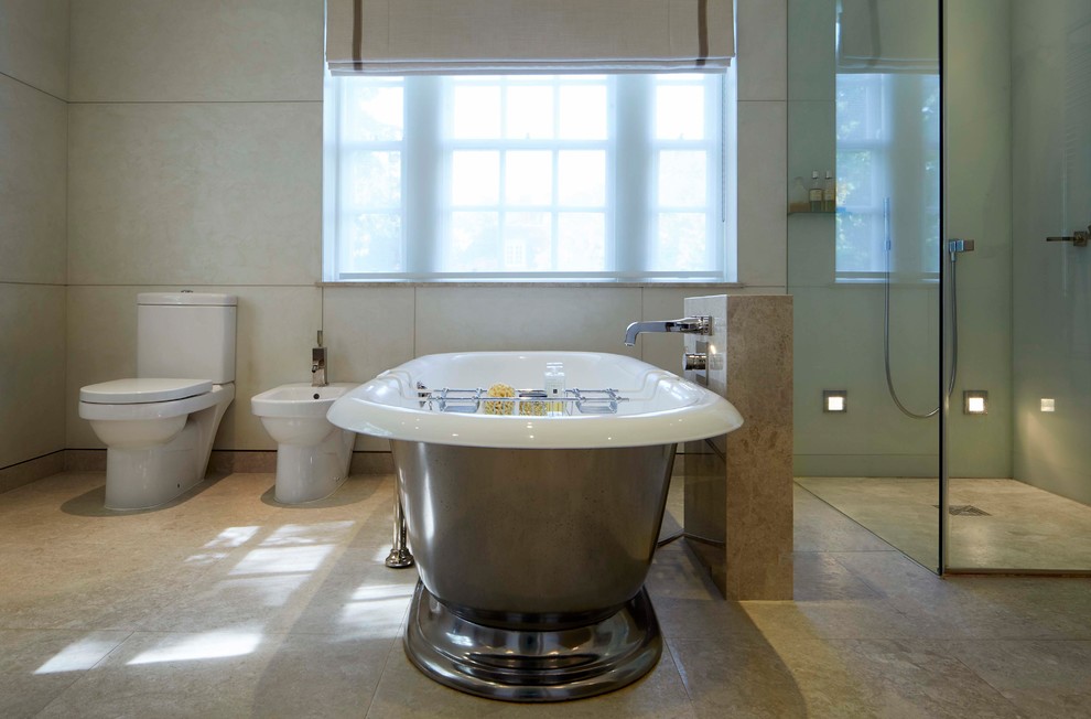 Foto di una stanza da bagno design di medie dimensioni con vasca freestanding, zona vasca/doccia separata, WC monopezzo e pavimento beige