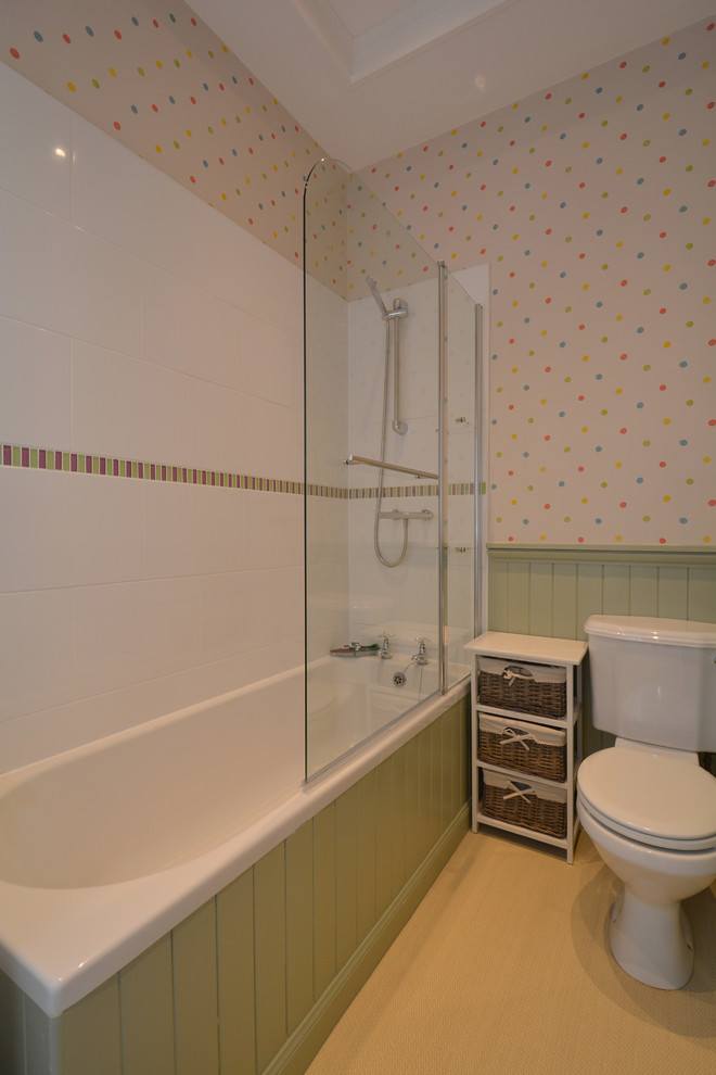 Cette image montre une salle de bain rustique de taille moyenne pour enfant avec une baignoire posée, un combiné douche/baignoire, WC suspendus et un mur multicolore.