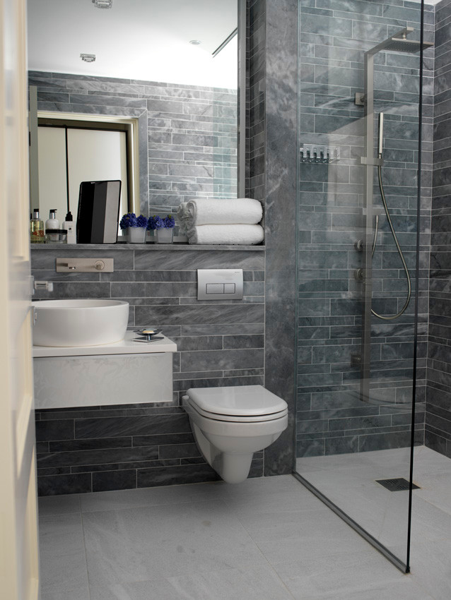 Photo of a medium sized contemporary shower room bathroom in Dublin with a console sink, flat-panel cabinets, engineered stone worktops, a walk-in shower, a wall mounted toilet, grey tiles, mosaic tiles, grey walls and marble flooring.