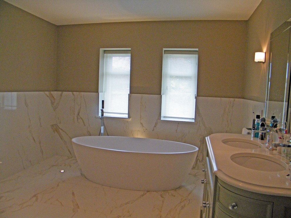 Design ideas for a large modern ensuite bathroom in Dublin with freestanding cabinets, medium wood cabinets, marble worktops, a freestanding bath, white tiles and yellow walls.