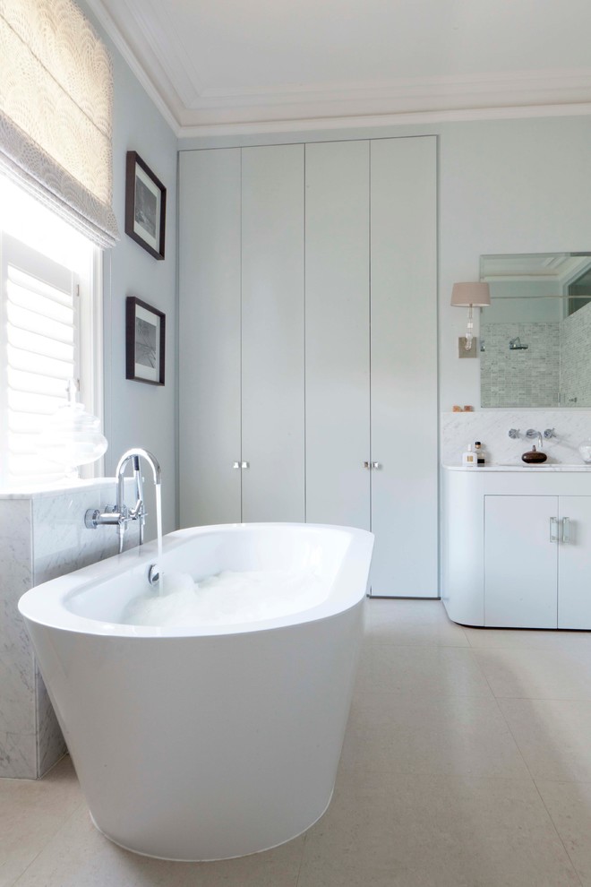 Idéer för att renovera ett funkis badrum, med släta luckor, vita skåp, ett fristående badkar och grå väggar